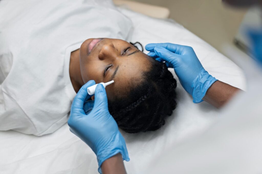 Huidtherapeut bereidt huid voor met wattenstaafje HBO-huidtherapeut bereidt de huid voor op microneedling — het aantal behandelingen wordt per huidtype bepaald