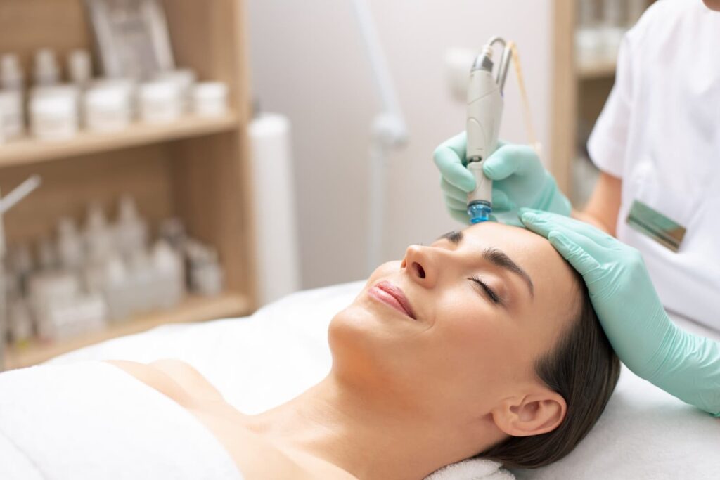 Huidtherapeut voert hydrafacial uit op voorhoofd bij ontspannen vrouw
Hydrafacial behandeling op voorhoofd en neus — huidtherapeut bereikbaar vanuit Den Haag
