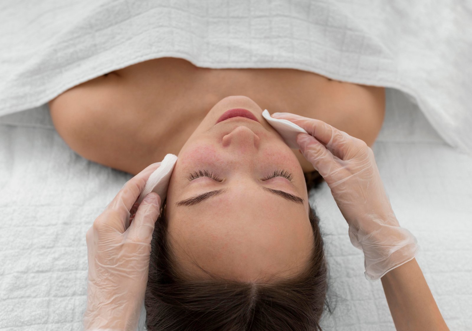 Huidtherapeut voert facial uit op wang met apparaat HBO-huidtherapeut behandelt wang met facial — behandeling voor cliënten uit Alkmaar en omgeving