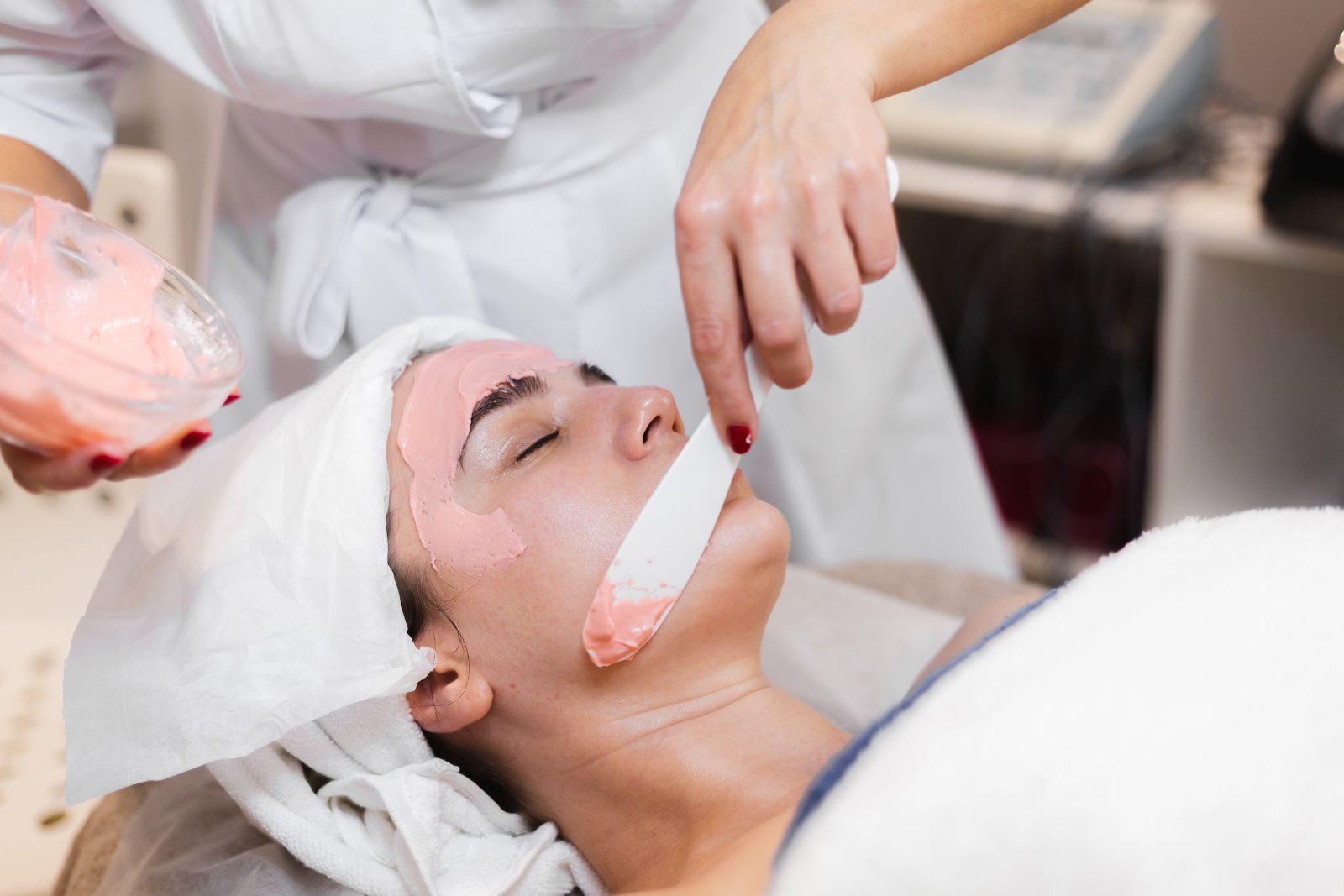 Huidtherapeut voert facial uit op wang met apparaat HBO-huidtherapeut behandelt wang met facial — behandeling voor cliënten uit Delft en omgeving