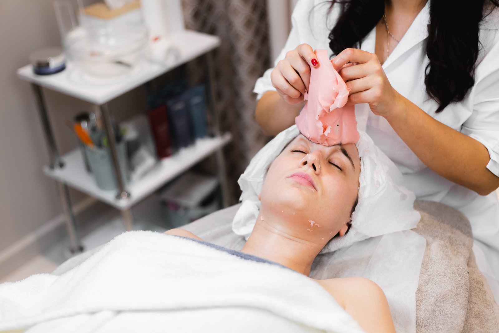 Huidtherapeut voert facial uit op wang met apparaat HBO-huidtherapeut behandelt wang met facial — behandeling voor cliënten uit Den Haag en omgeving