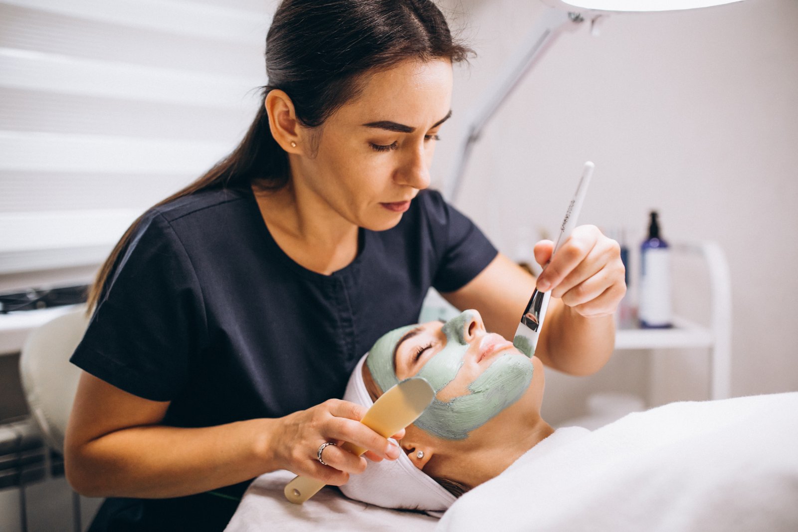 Huidtherapeut voert facial uit op wang met apparaat HBO-huidtherapeut behandelt wang met facial — behandeling voor cliënten uit Katwijk en omgeving