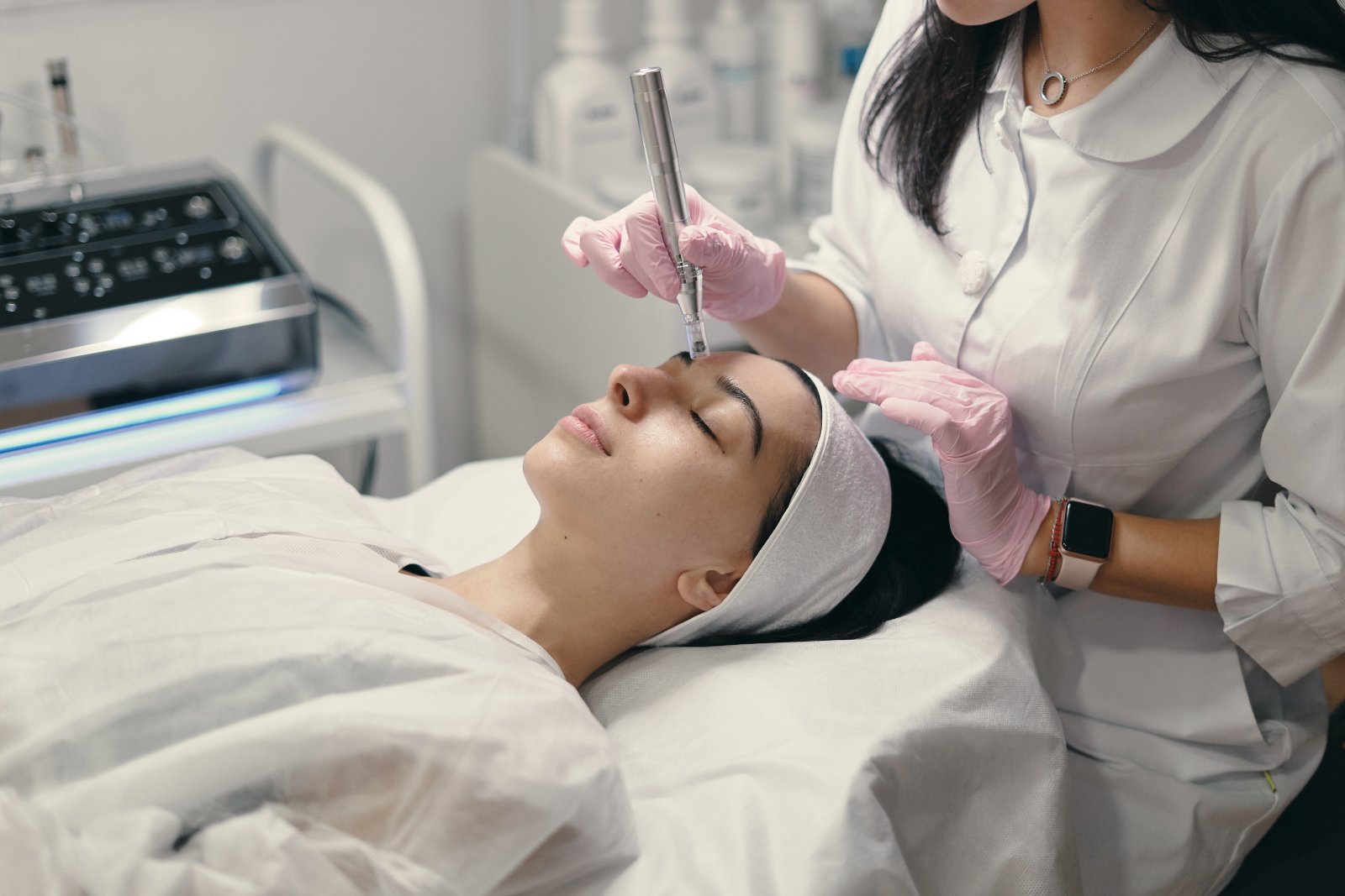 Huidtherapeut voert microneedling uit op wang met apparaat HBO-huidtherapeut behandelt wang met microneedling — behandeling voor cliënten uit Rotterdam en omgeving